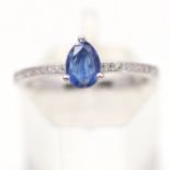 A 925 silver ring set with a pear cut sapphire and white stone set shoulders, (P).