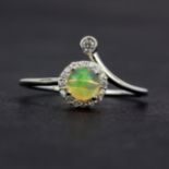 A 925 silver crossover ring set with cabochon cut opal and white stones, (O).