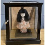 A cased Japanese doll, case size 24 x 20 x 27cm.
