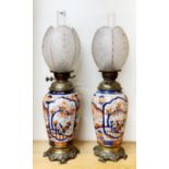 An impressive pair of 19th C Japanese Imari brass oil lamps with interesting frosted glass shades,