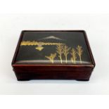 An Japanese hardwood box inset with a silver and gold decorated bronze panel, 14 x 10 x 5cm.