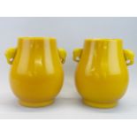 A pair of superb Chinese imperial yellow Peking glass vases with elephant head handles, H. 27cm.