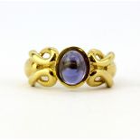 A 10ct yellow gold (stamped 10K) solitaire ring set with an oval cabochon sapphire, (L).
