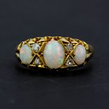 A hallmarked 18ct yellow gold ring set with oval cabochon opals and diamonds, (N).