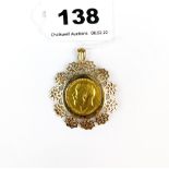 A 1912 gold sovereign in an ornate 9ct gold pendant mount.