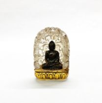A Chinese carved crystal shrine, H. 9cm. housing a small bronze Buddha.