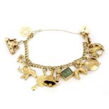 A heavy hallmarked 9ct yellow gold charm bracelet with heart clasp, L. 11cm.