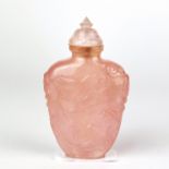 A Chinese carved rose quartz snuff bottle decorated with dragons and lion ring side handles, H. 8.