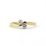 A hallmarked 9ct yellow gold crossover ring set with two brilliant cut diamonds, approx. 0.20ct