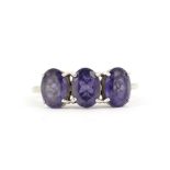 A hallmarked 9ct white gold ring set with oval cut tanzanites, (M.5).