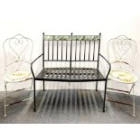 A metal garden bench and two folding garden chairs.