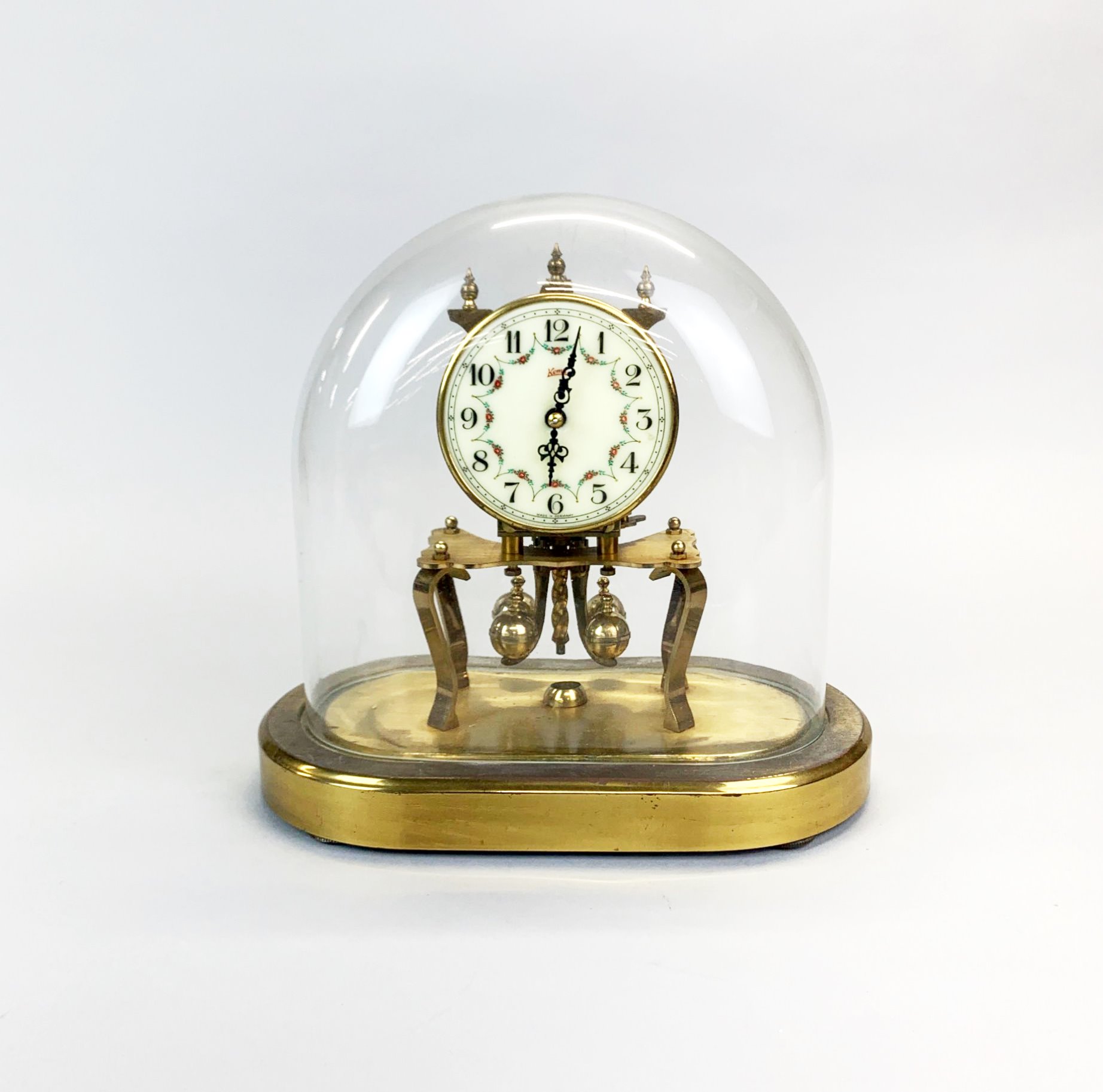 A Kuma mantel clock under glass dome, H.23cm W. 22cm.