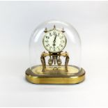 A Kuma mantel clock under glass dome, H.23cm W. 22cm.