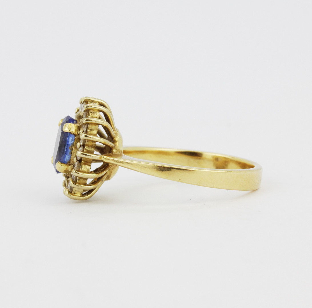 An 18ct yellow gold cluster ring set with an oval cut tanzanite surrounded by diamonds, tanzanite - Image 2 of 3