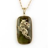 A hallmarked 9ct yellow gold jade set pendant of a dragon with a ruby eye and Chinese characters, L.