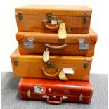 Four vintage leather suitcases.