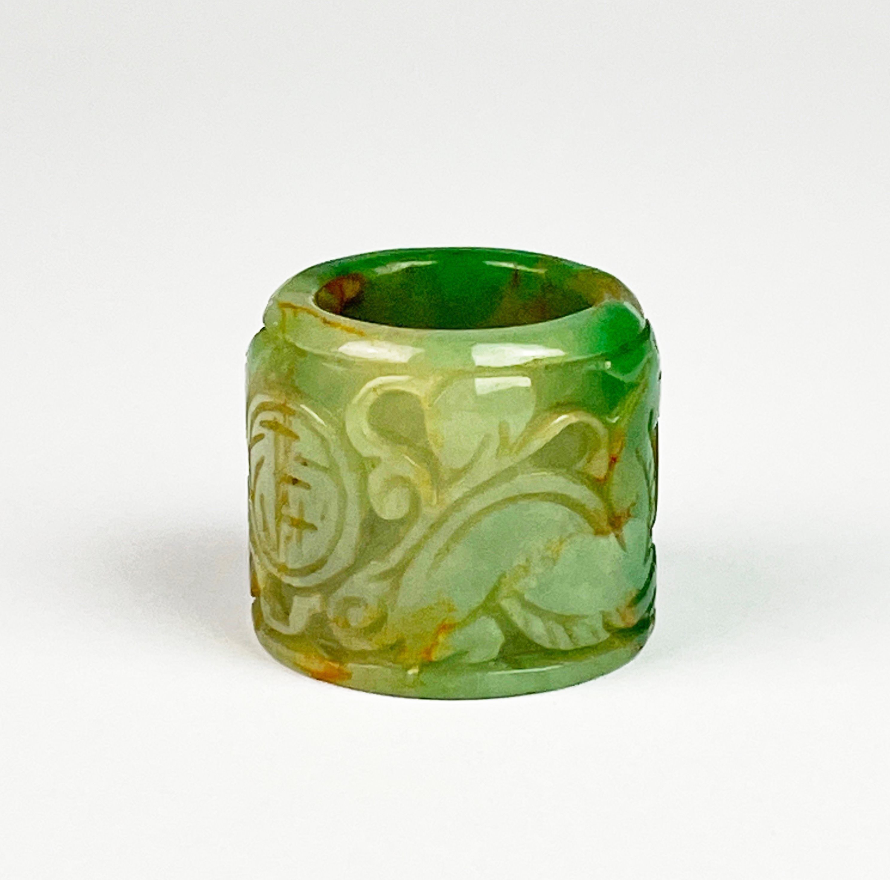 A Chinese carved green jade archer's thumb ring, W. 3cm.