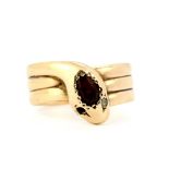 A hallmarked 9ct yellow gold snake ring set with an oval cut garnet and diamond set eyes (one