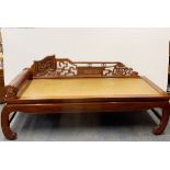 A Chinese carved hardwood day bed with revolving pillow, L. 190cm D. 85cm.