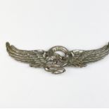 A large flying dragon design metal brooch, W. 11cm.