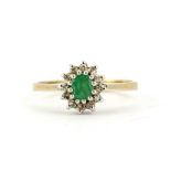 A hallmarked 9ct yellow gold ring set with an oval cut emeralds and diamonds, (M).