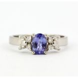 A 14ct white gold (stamped 14K) ring set with an oval cut tanzanite and diamonds, (P.5).