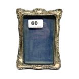 A hallmarked silver fronted photo frame, H. 16cm.