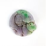 A Chinese carved lavender and green jade figure of a fish with lotus shaped fin and spitting cash