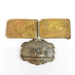 Three Tiffany style American brass belt buckles, W. 10cm.