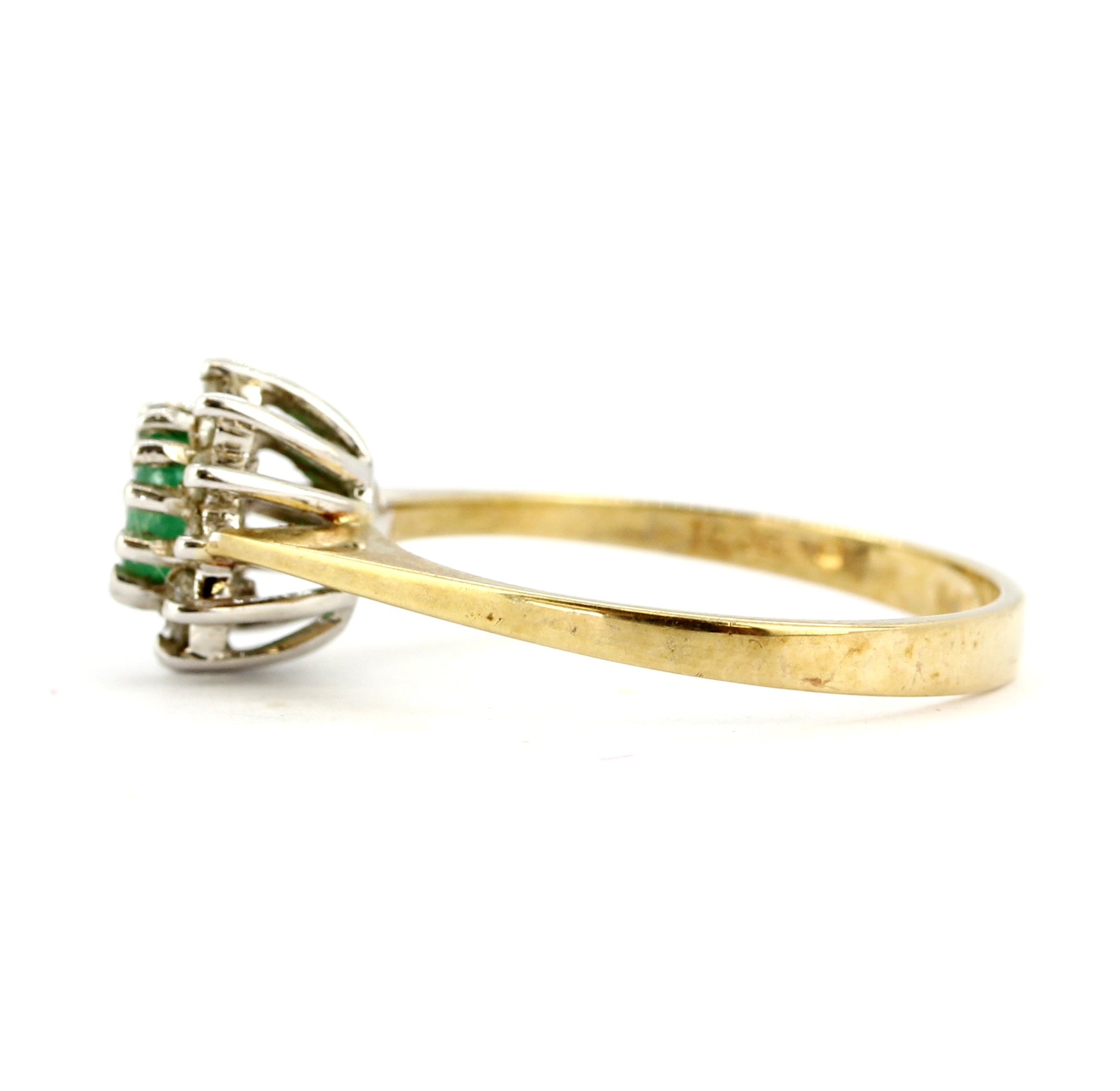 A hallmarked 9ct yellow gold ring set with an oval cut emeralds and diamonds, (M). - Image 2 of 2