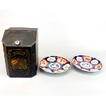 A toleware metal tea caddy and two Imari plates, tea caddy H. 24cm.