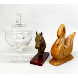 A large glass jar and cover H. 37cm, together with a carved wooden swan and a horse head.