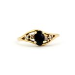 A 9ct yellow gold (stamped 9K) ring set with an oval cut sapphire and diamonds, (K.5).