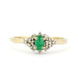 A hallmarked 9ct yellow gold ring set with an oval cut emerald and diamonds, (N.5).