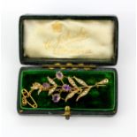 A boxed antique 9ct yellow gold brooch set with oval and pear cut amethysts and seed pearls, L.