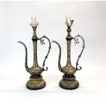 A pair of early 20th century Middle Eastern mounted, engraved and laquered brass jugs on ornate