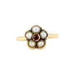 A boxed yellow metal (tested minimum 9ct gold ring) flower shaped ring set with a garnet and seed