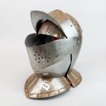 A reproduction Medieval knights steel helmet with wooden stand, H. 35cm.