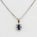 A white metal (tested minimum 9ct) pendant set with an oval cut sapphire surrounded by diamonds on