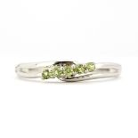 A 9ct white gold ring set with peridots, (N).