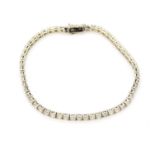 A 14ct white gold tennis bracelet set with brilliant cut diamonds, approx. 4ct overall, L. 18cm.