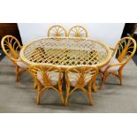 A large bamboo dining table with plate glass top together with eight matching upholstered chairs,
