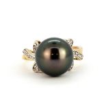 A 9ct white gold ring set with a black pearl and diamonds, (N).