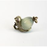 A white metal and jade egg and chick pendant with ruby eyes, H. 3.5cm. Tested silver and probably