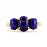 A 9ct yellow gold ring set with three cabochon cut lapis lazuli, (S).