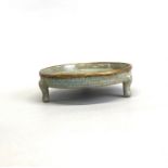A Chinese celadon crackle glazed shallow dish raised on three feet, Dia. 14cm, H. 3.5cm.