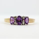 A 9ct yellow gold ring set with oval cut amethysts and diamonds, (S).