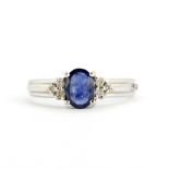 A 14ct white gold ring set with an oval cut sapphire and brilliant cut diamonds, (M.5).