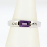 A 9ct white gold ring set with a baguette cut amethyst and diamond set shoulders, (M.5).