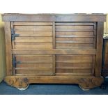 An antique eastern hardwood cabinet on wheels with two pairs of sliding doors and replacement top,
